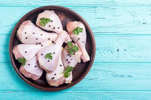 Muslos de pollo crudo con especias y perejil Fondo de comida