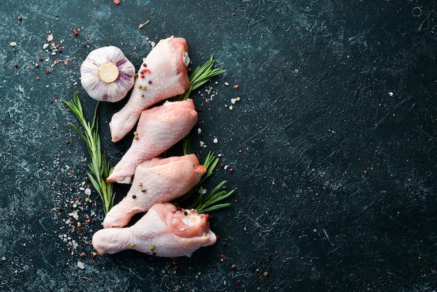 Muslos de pollo crudo con especias de romero y verduras Vista superior Espacio libre para el texto