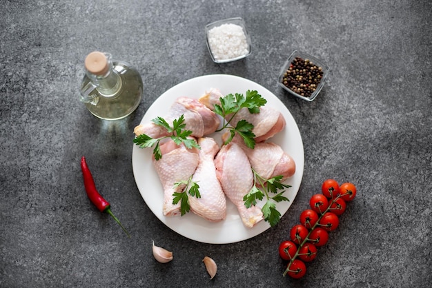 muslos de pollo crudo con especias sobre un fondo de piedra