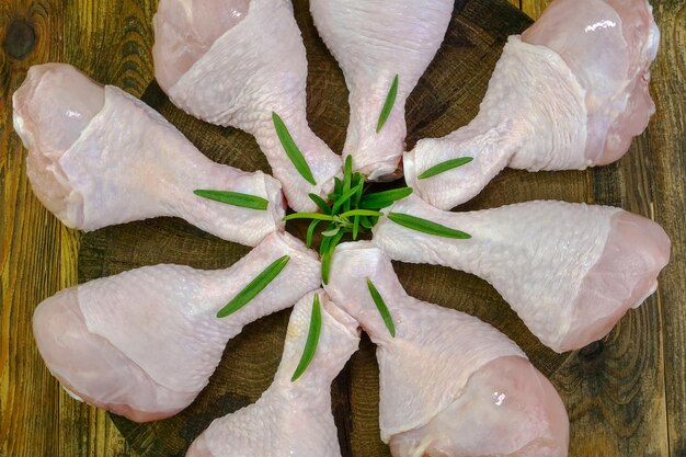 Foto muslos de pollo crudo fresco con ramitas de romero