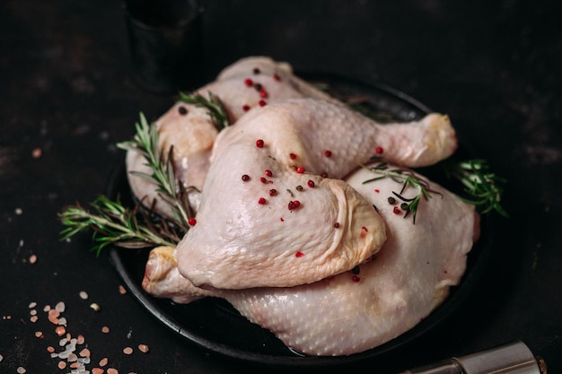 muslos de pollo crudo sobre un fondo oscuro