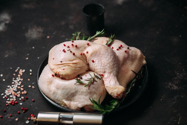 muslos de pollo crudo sobre un fondo oscuro