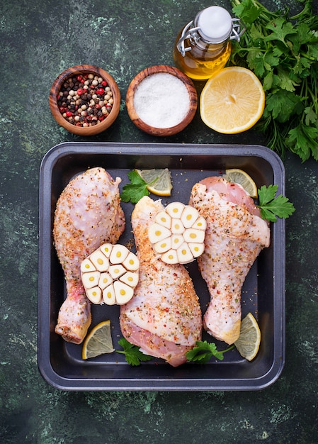 Foto muslos de pollo crudos con especias listos para cocinar