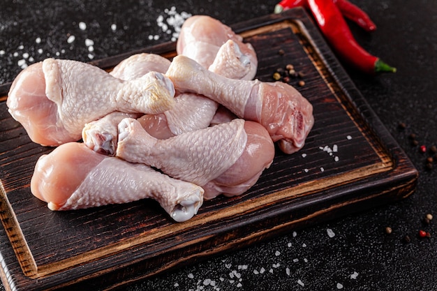 Foto muslos de pollo se encuentran sobre una tabla de madera