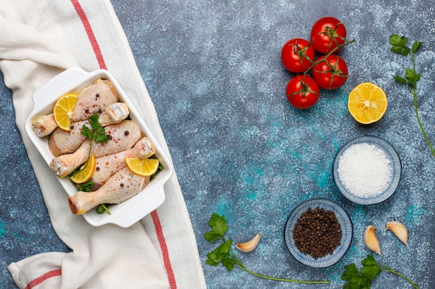 Muslos de pollo con especias y sal listos para cocinar en la tabla de cortar.