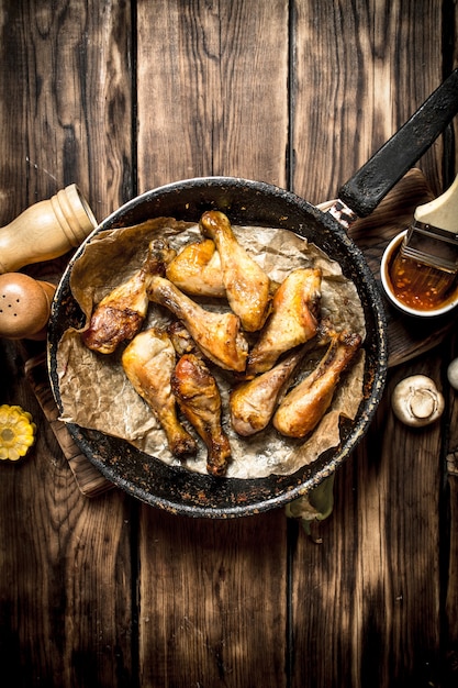 Muslos de pollo frito con salsa de tomate en una mesa de madera