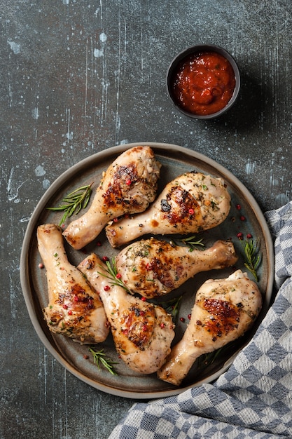 Muslos de pollo a la plancha con salsa de tomate en plato de cerámica