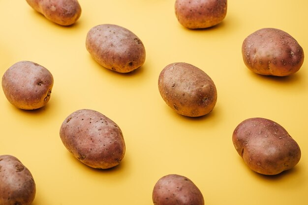 Foto muster roher ganzer frischer kartoffeln auf gelbem hintergrund