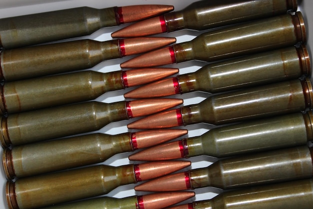 Muster von scharfer Munition, ausgelegt von Kugel zu Kugel auf einem weißen Hintergrund, detailliertes Stock-Foto