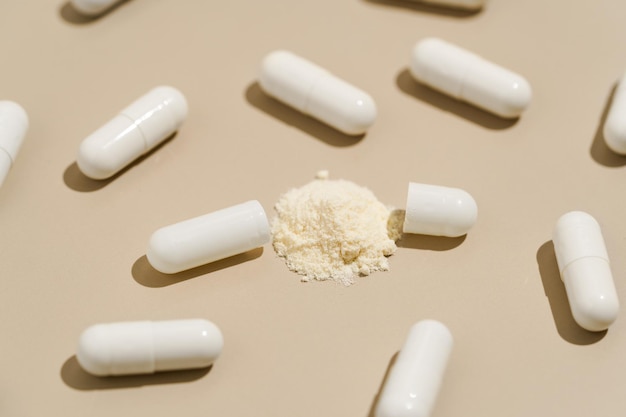Muster von weißen Pillen, Kapseln und Wirkstoff in Pulver auf beige isoliertem Hintergrund Konzept der Medizin natürliche Nahrungsergänzungsmittel Gesundheit und Antibiotika