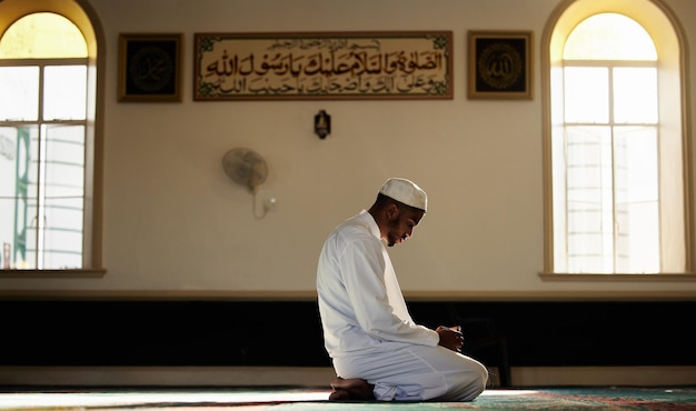 El musulmán que reza y el hombre espiritual en la mezquita para la adoración de Dios Allah y la atención para la paz la oración de la persona y el respeto por la religión del Islam o la gratitud matutina por la santa fe islámica con esperanza