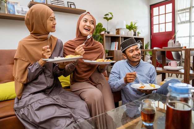 Musulmanes cenando iftar sentados en el sofá