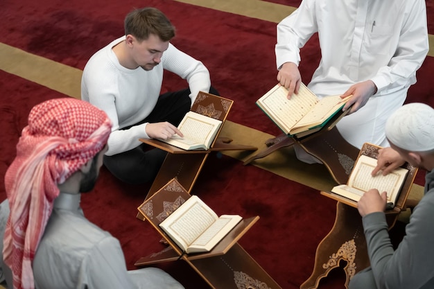 musulmanes en la mezquita leyendo el Corán juntos concepto de educación islámica y escuela del libro sagrado kuran