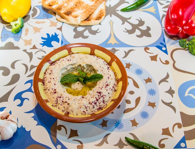 Mutabal oder Mutabel mit Olivenöl, das in einem auf dem Tisch isolierten Gericht serviert wird.