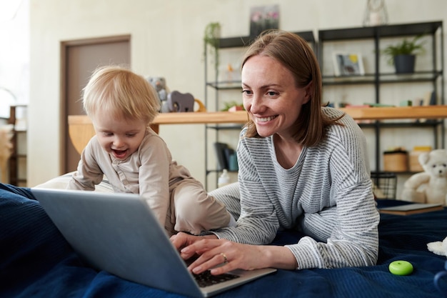 Mutter arbeitet online am Laptop