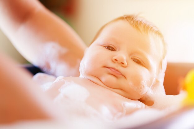 Mutter badet ihr Baby in der Badewanne