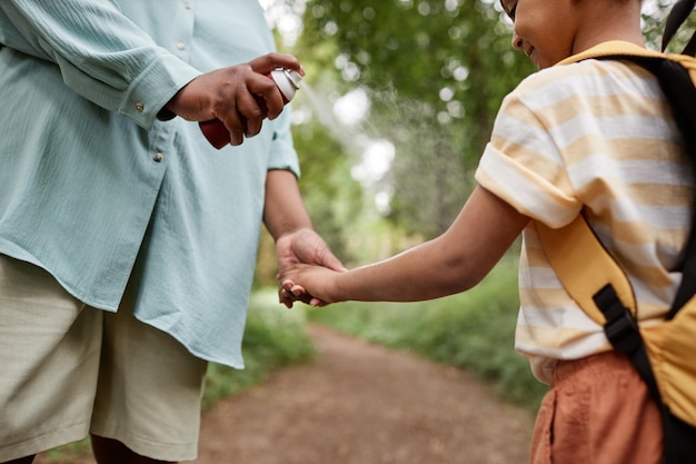 Mutter benutzt babysicheres Insektenschutzmittel für Tochter beim gemeinsamen Wandern