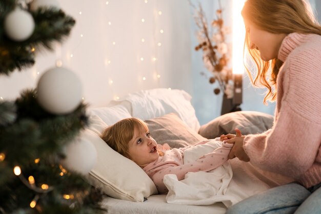 Mutter bringt ihre kleine Tochter ins Bett