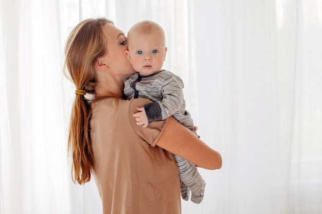 Mutter, die Baby küsst und umarmt