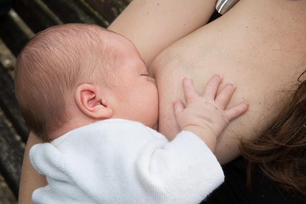 Foto mutter, die ein nettes baby isoliert stillt