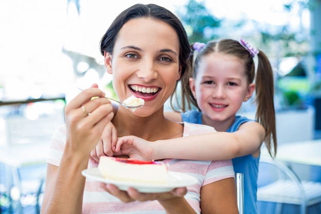 Mutter, die ein Stück Kuchen mit ihrer Tochter isst