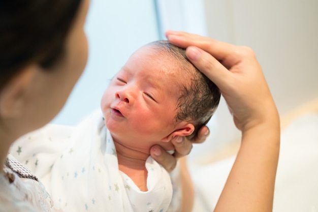 Mutter, die ihr Baby erstes Bad gibt, Neugeborenes Konzept des Badens