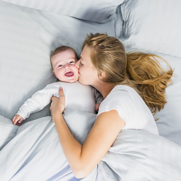 Foto mutter, die ihr baby küsst