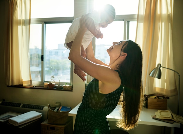 Mutter, die ihr Baby mit Liebe hochhält