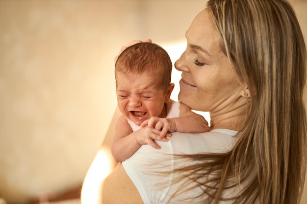 Mutter, die ihr neugeborenes Baby in den Händen hält