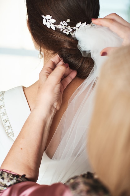 Mutter, die ihre Tochter für einen Hochzeitstag vorbereitet.