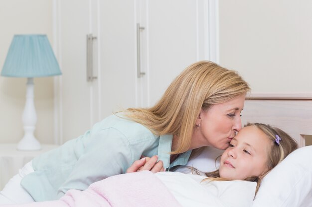 Mutter, die ihre Tochter küsst