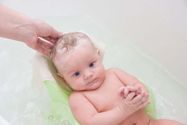 Mutter, die ihren Sohn beim Baden des Standes wäscht