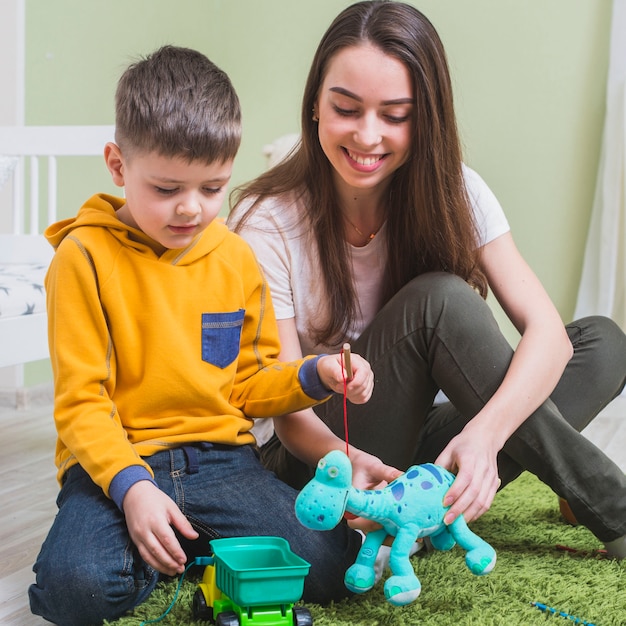 Foto mutter, die spielwaren mit sohn spielt