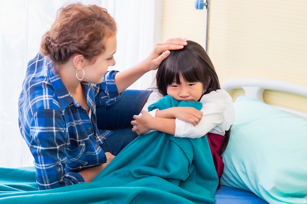 Mutter diskutiert mit ihrer geduldigen Tochter im Krankenhaus