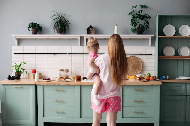 Mutter frühstückt mit ihrer schönen Tochter in der Küche