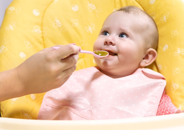 Mutter füttert Baby mit Gemüsepüree. Selektiver Fokus. Essen.