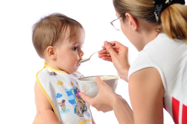 Mutter füttert Baby mit Löffel