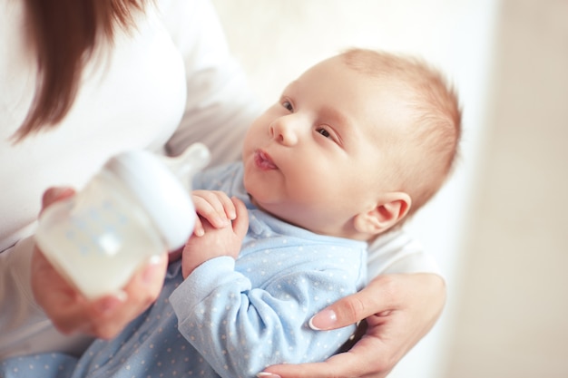Mutter füttert Baby mit Milch in der Flasche