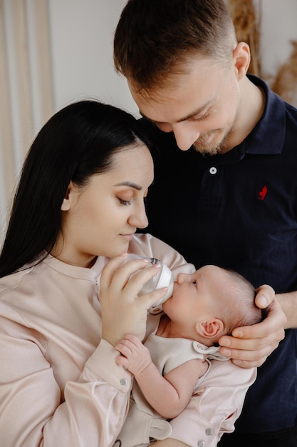 Mutter füttert ihr Baby mit Babyflasche Mama und Papa füttern das Baby