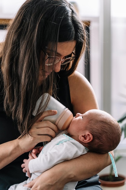 Mutter füttert ihr neugeborenes Baby aus einer Flasche