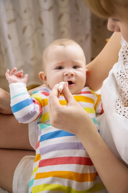 Mutter gibt dem kleinen Baby Koliken Medizin Selektiver Fokus