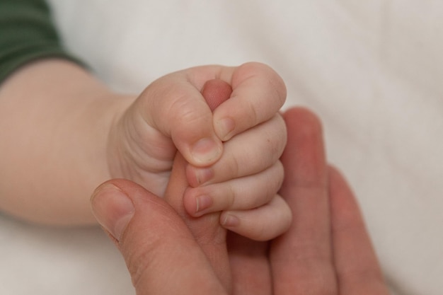 Mutter hält das Baby an der Hand