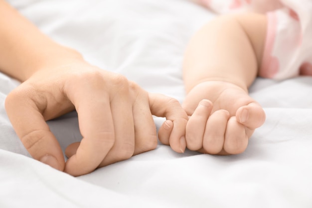 Mutter hält die Hand ihres Babys in Nahaufnahme