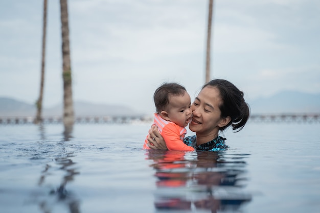 Mutter hält ihr Baby beim Schwimmenlernen