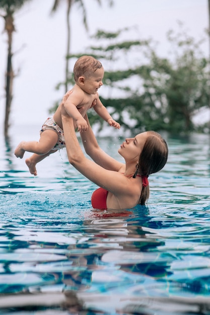 Mutter hält ihr Baby in einem Pool