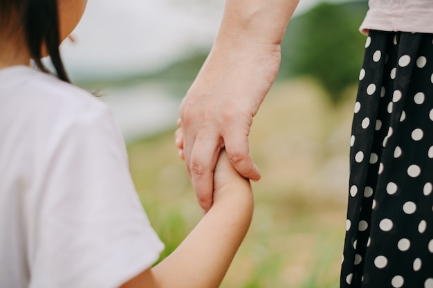 Mutter hält ihre Kinderhand. Bild für das Konzept der Liebe, der Bindung und der Familie.