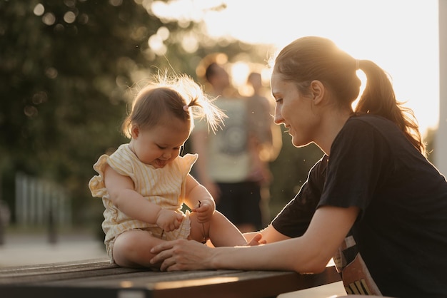 Mutter hält ihre kleine Tochter davon ab, bei Sonnenuntergang zu fallen