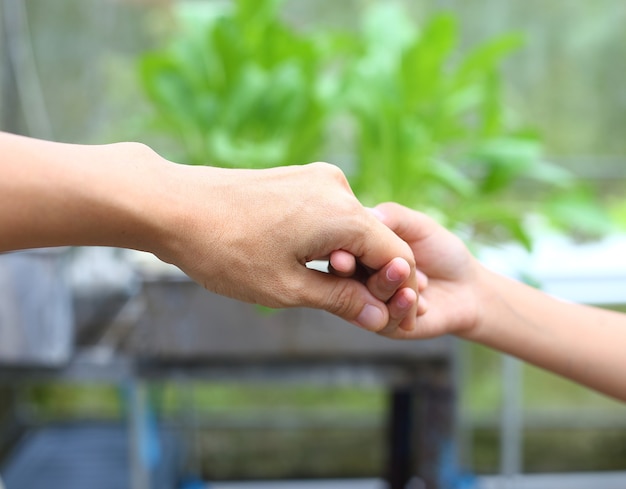 Foto mutter hält kinderhand zum helfen und geht zusammen