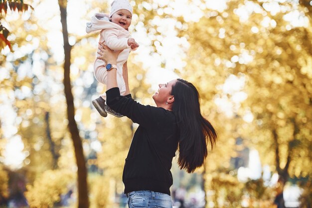 Mutter in Freizeitkleidung mit ihrem Kind ist im schönen Herbstpark.
