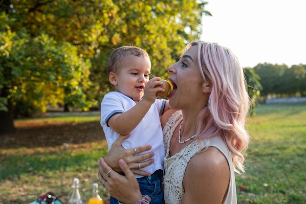 Mutter isst einen apfel, den ihr sohn während eines picknickkonzepts für gesunde ernährung gegeben hat